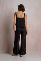 The back of woman wearing a black outfit with lace details 