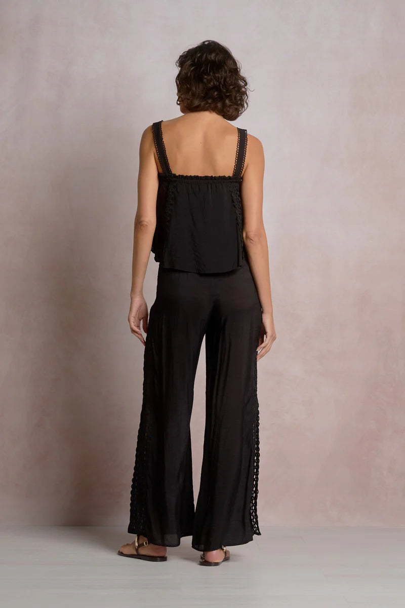 The back of woman wearing a black outfit with lace details 