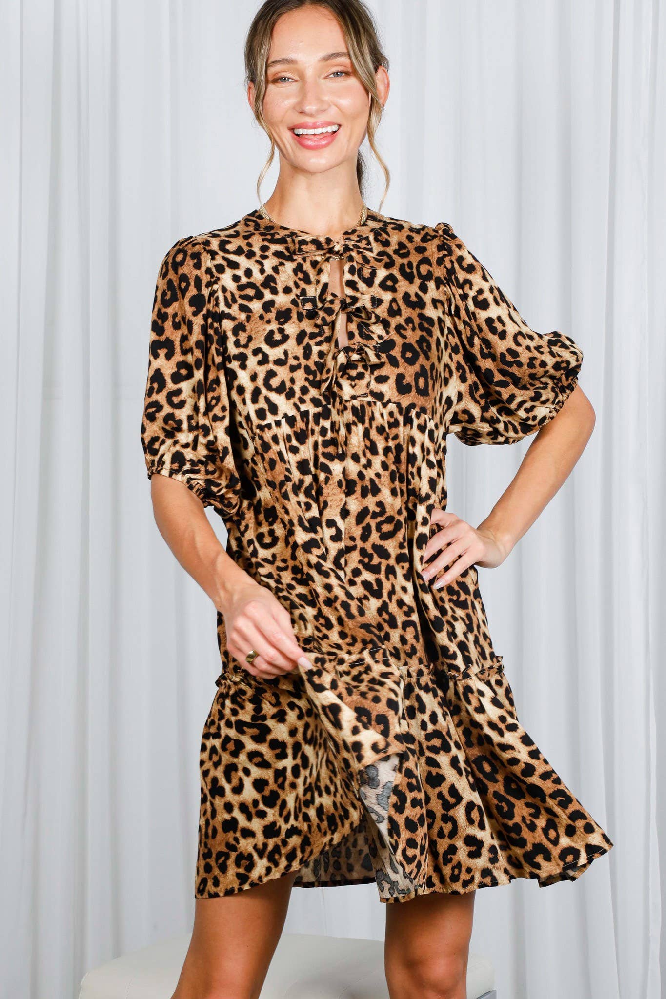 Woman wearing a leopard print dress against a white background