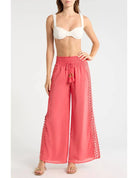 Woman wearing coral pants with lace details 