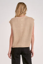 Back of woman wearing a beige knitted vest 