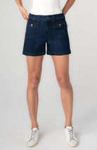Person wearing dark blue denim shorts 