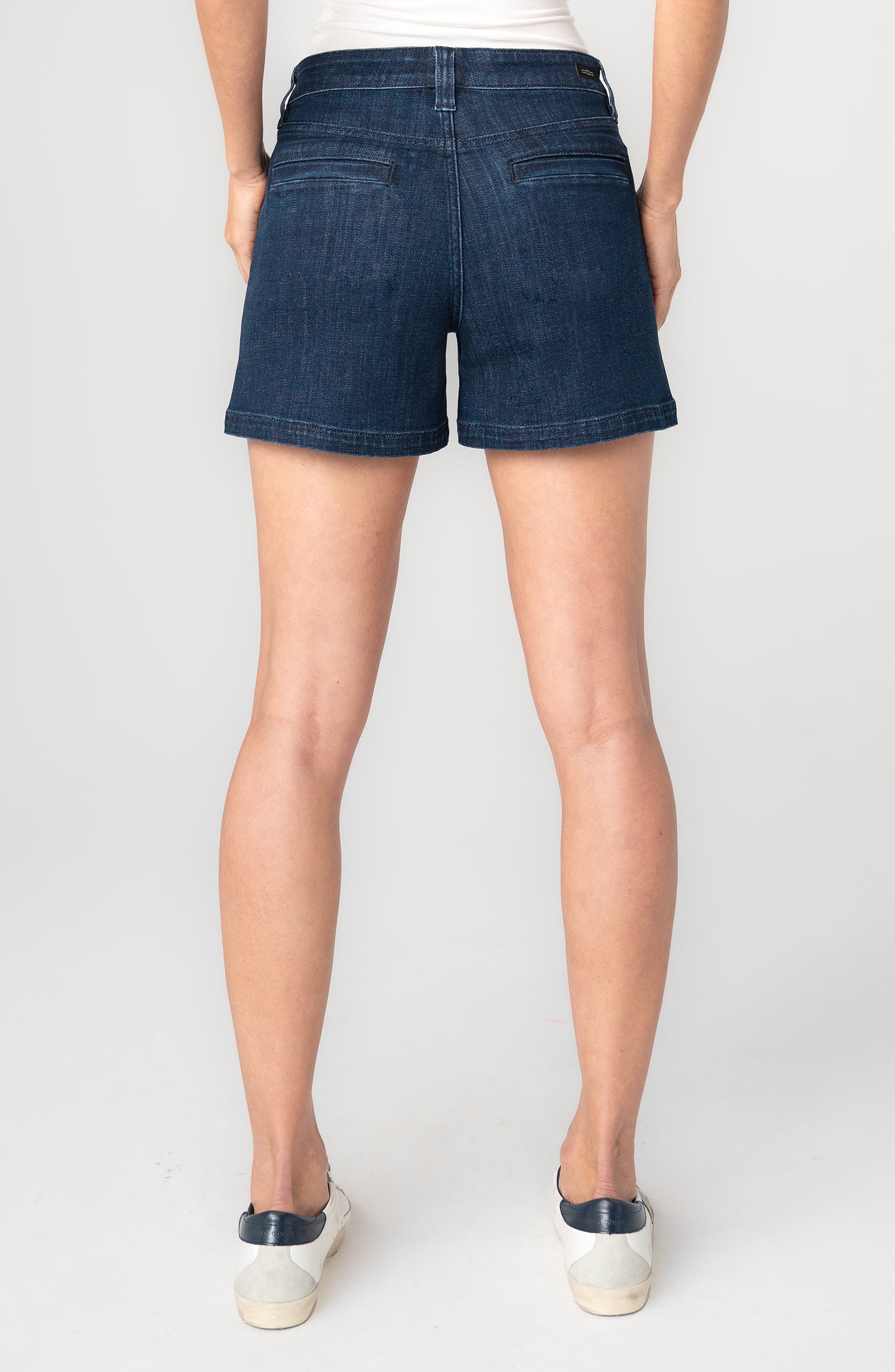Person wearing dark blue denim shorts