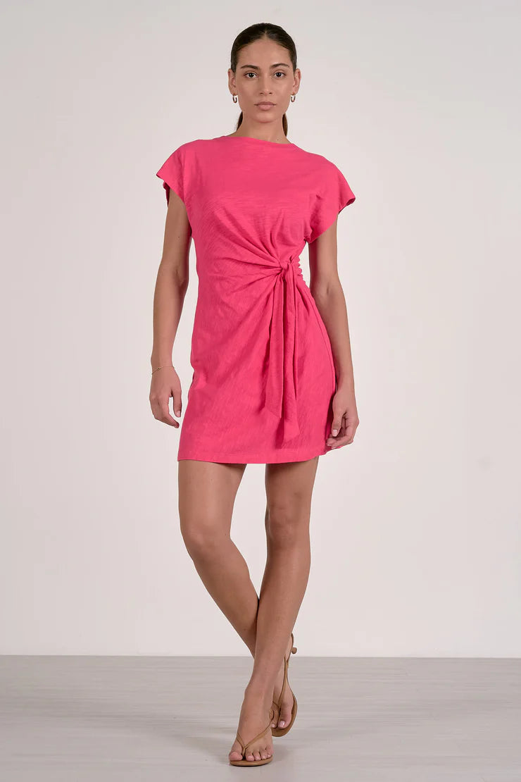 Woman wearing a bright pink dress with a tie waist 